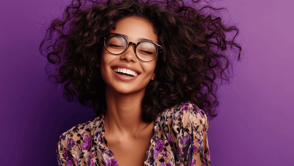 Como Ter Um Glow Up - Cuide dos cabelos - mulher sorridente com seus cabelos ondulados livres ao ar de forma bem contente com seus fios.