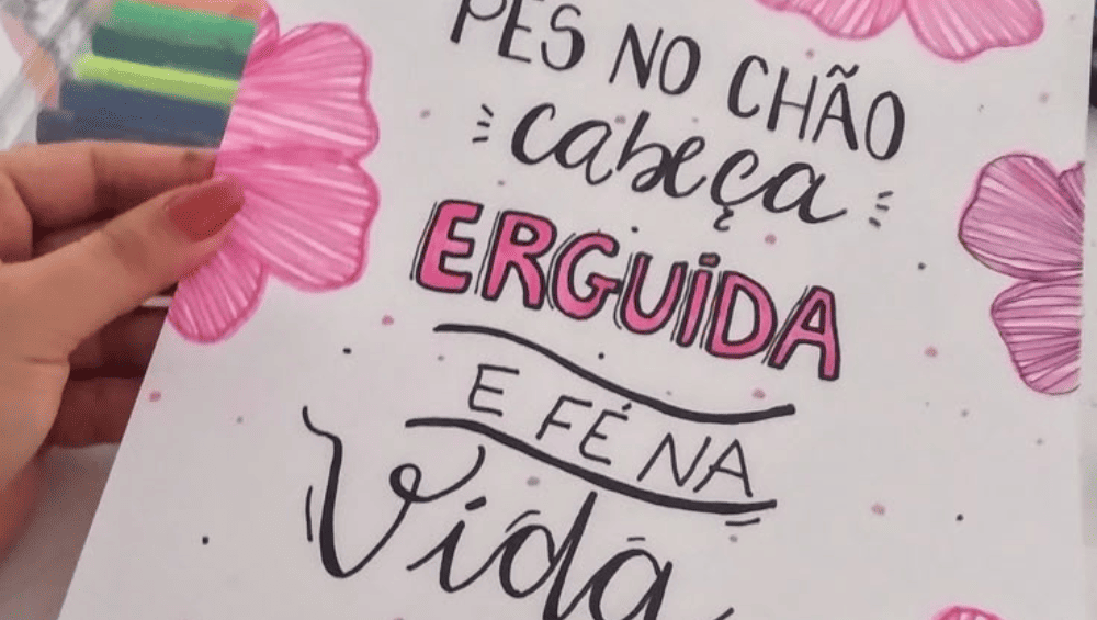 Frases para Aumentar Autoestima, imagem de uma mão segurando uma folha com essa frase de motivação escrita "pés no chão, cabeça erguida e fé na vida"