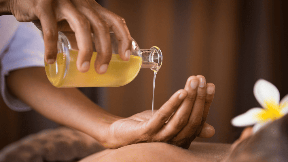 Cuidados com a Pele Orgânicos - Aposte em Óleos Vegetais para Hidratação Cuidados com a Pele Orgânicos - Aposte em Óleos Vegetais para Hidratação - imagem de uma mulher deitada e outra colocando oleo na mão para pode fazer uma massagem relaxante.