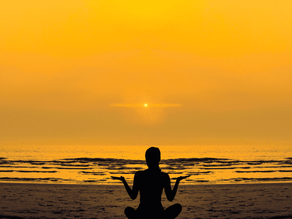 O que significa viver com propósito - Sirva com o que você tem hoje O que significa viver com propósito - Sirva com o que você tem hoje - imagem de uma mulher de frente ao por do sol praticando meditação