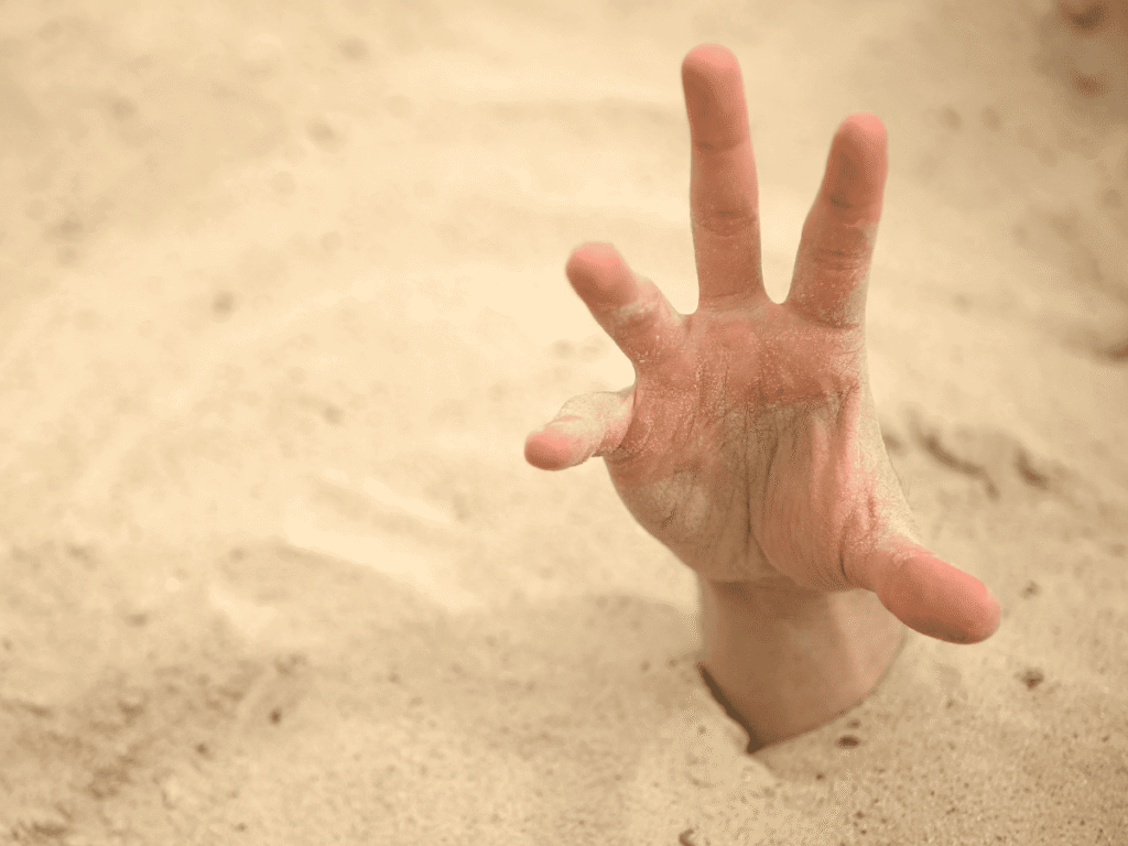 Por Que Você Não Emagrece Nem Comendo Apenas Salada - O Modo de Sobrevivência O Erro que te Impede de Emagrecer - imagem de uma mão saindo da areia.