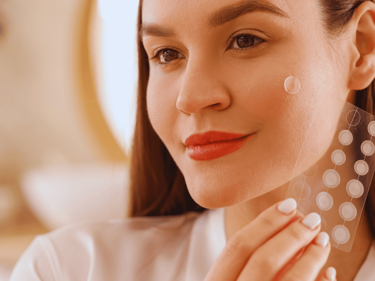 Testei os adesivos secativos que viralizaram Eles realmente somem com a espinha - imagem de uma mulher segurando uma cartela de adesivos secativos transparente.